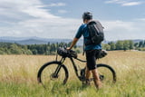 Mann mit Bikepacking-Ausrüstung in Wiese