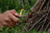 Person zündet Lagerfeuer an