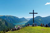 Mountainbiker und Bergsteiger teilen sich den Platz am Gipfelkreuz des Feilkopfes.