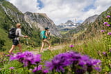 Ein Pärchen wandert auf dem Bergpilgerweg mit Blick zum Großglockner.