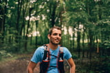 Mann mit Trailrunning-Rucksack im Wald