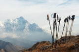 Zahlreiche Wanderstöcke vor einer Bergkulisse.