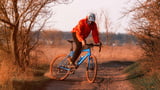 Gravel Bikes im Test, Mann fährt auf blauen Gravel Bike