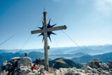 Klassisch schön: das Gipfelkreuz auf dem Guffert mit seiner grandiosen Aussicht auf die zentralen Alpen.