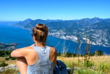 Frau genießt die Aussicht am Monte Baldo über dem Gardasee